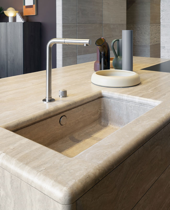 Dettaglio lavello integrato in travertino della cucina Orizzonte Pianca, design elegante e materiali naturali di pregio.